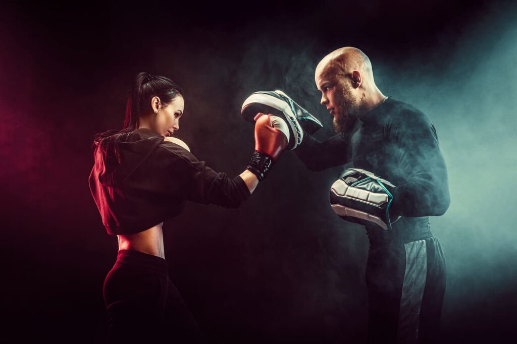 woman-exercising-with-trainer-at-boxing-and-self-defense-lesson (1)