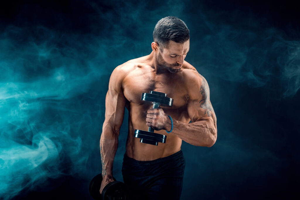 young-ripped-man-bodybuilder-with-perfect-abs-shoulders-biceps-triceps-and-chest-posing-with-a-dumbbell (1)